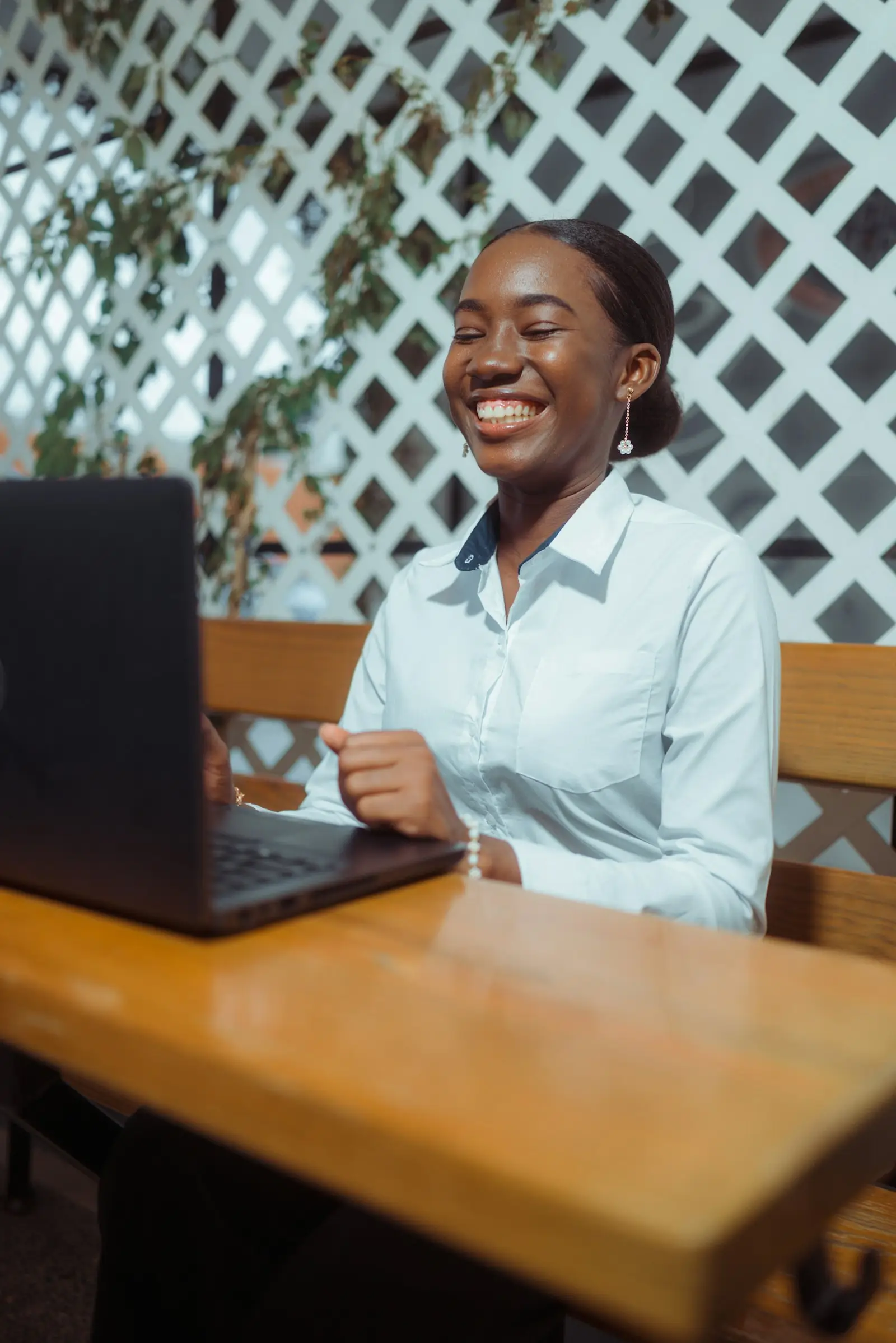 A smiling young woman working on a laptop